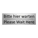 Bitte hier warten - Please Wait Here