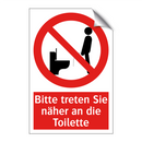 Bitte treten Sie näher an die Toilette