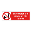 Bitte treten Sie näher an die Toilette