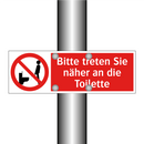 Bitte treten Sie näher an die Toilette