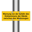 Warnung vor der Gefahr des Einklemmens der Hände zwischen den Werkzeugen